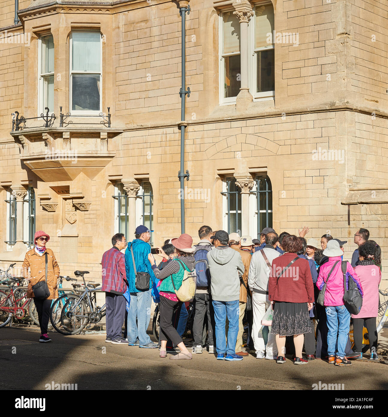 Gruppe der chinesischen Touristen auf der Straße vor dem Eingang zum Balliol College der Universität Oxford, England. Stockfoto