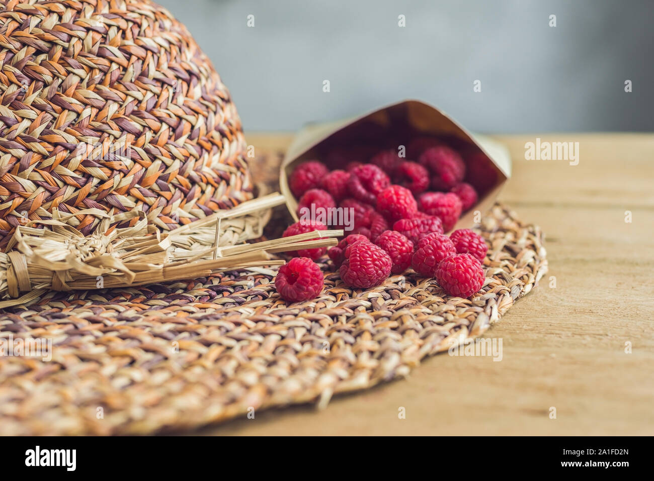 Sommer Urlaub, Ferien, Entspannung Konzept. Himbeeren, Stroh Hut, auf Holz- Hintergrund. Freier Text kopieren. Sommer vibes Konzept Stockfoto