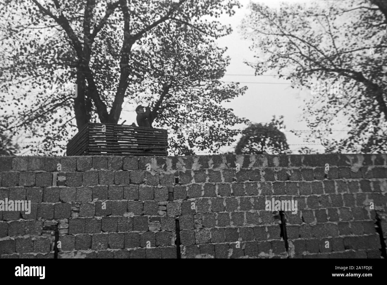 DDR-Grenzsoldat hinter der Mauer in Berlin, Deutschland 1962. Soldat der DDR-Grenztruppen Truppen hinter der Mauer in Berlin, Deutschland 1962. Stockfoto