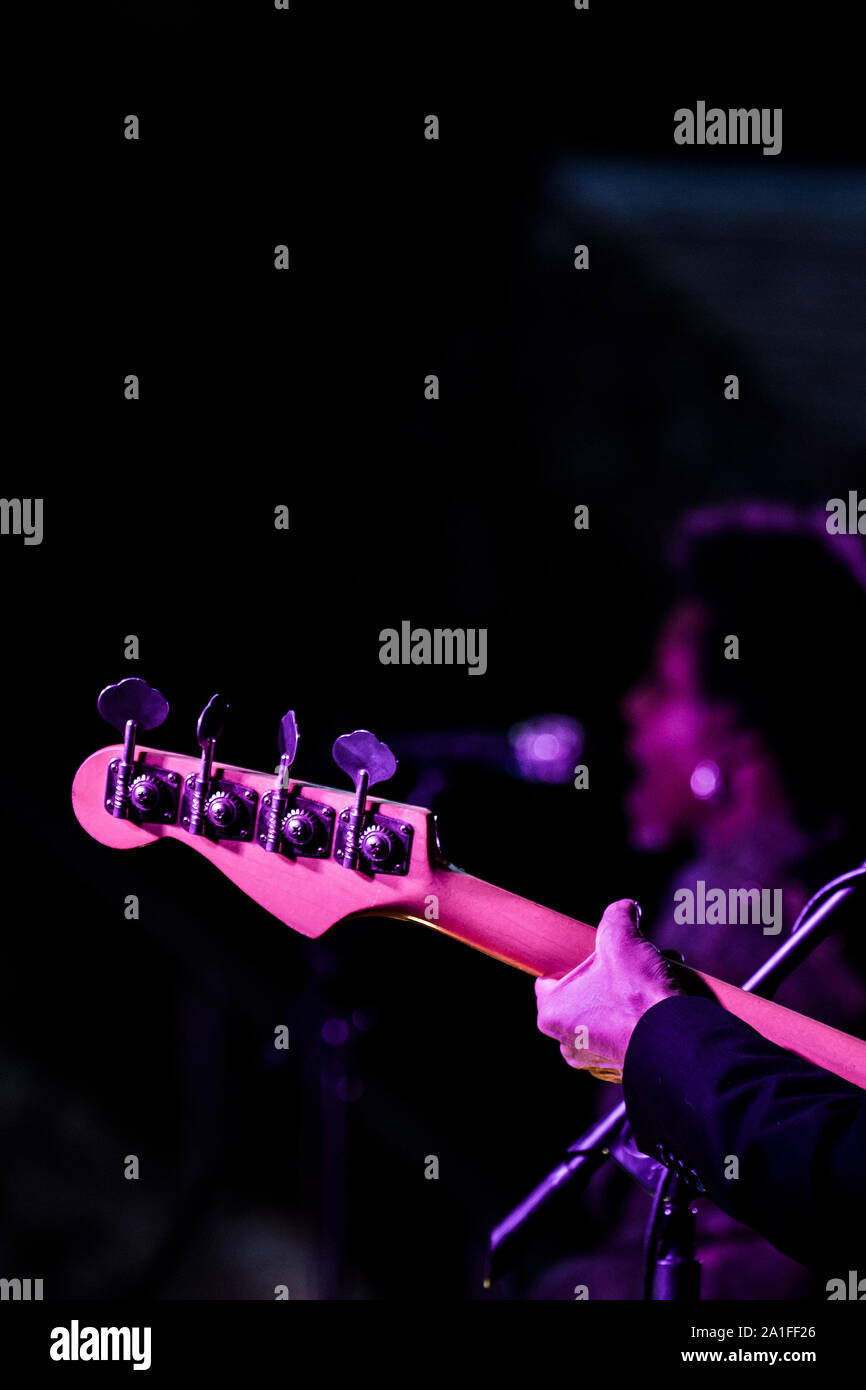 Die Kopfplatte und Tuning Tasten auf einer base Gitarre von einem Musiker gespielt wird. Stockfoto