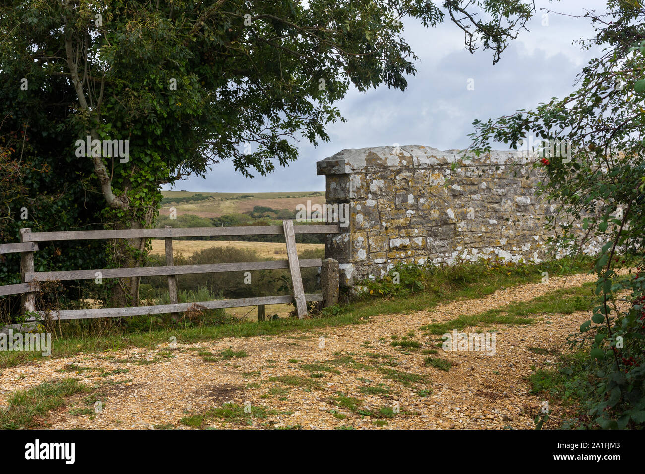 Ländliche Szene einer Brücke aus Stein an der Wand und Holz Zaun entlang einer ruhigen Pathway in Dorset, Großbritannien Stockfoto