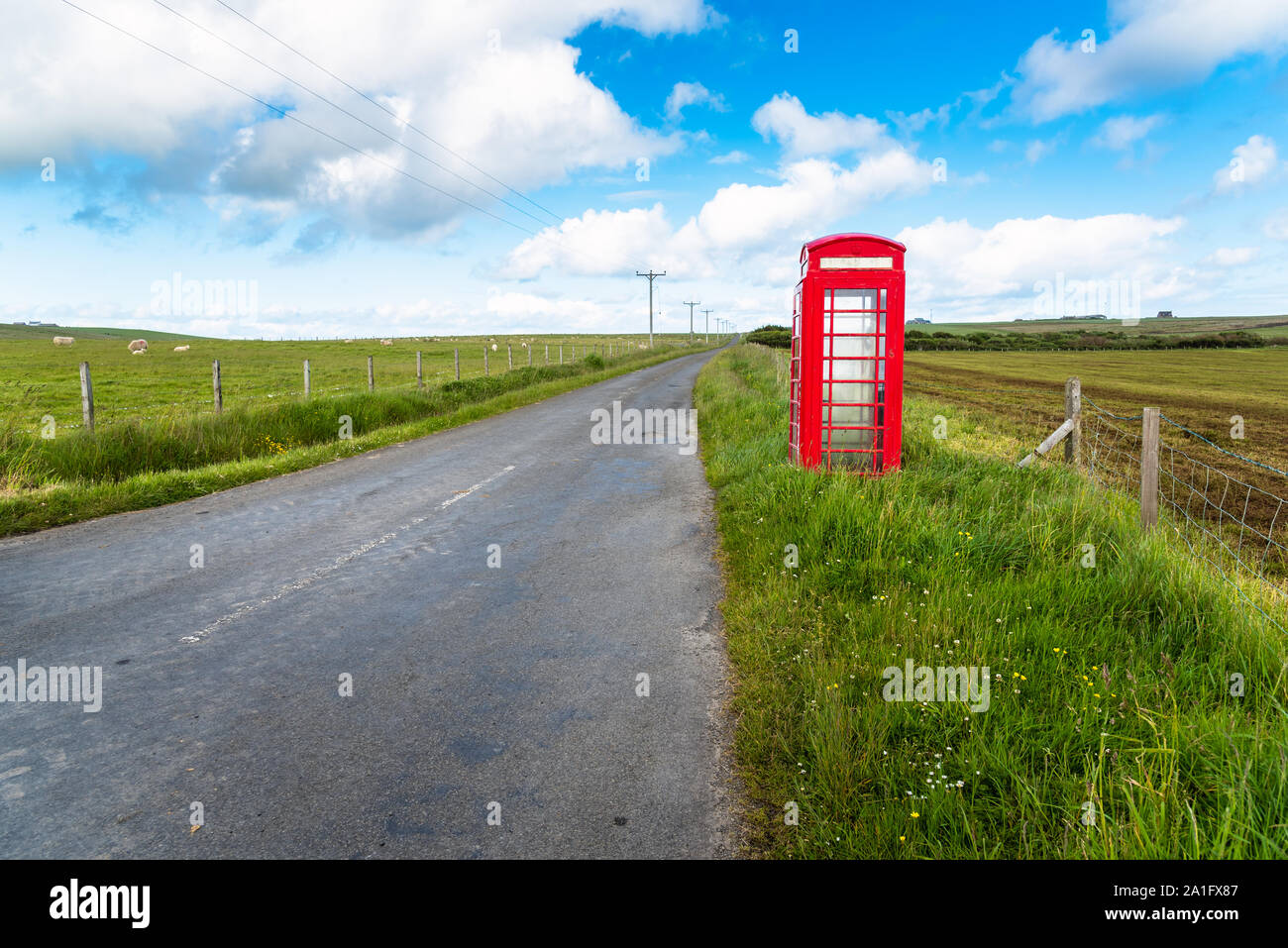 Einsame britische Telefonzellen auf einer Landstraße an einem klaren Frühlings Stockfoto