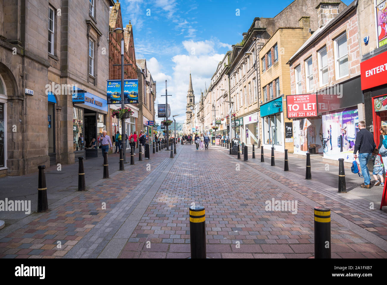 Gepflasterten Fußgängerzone mit Geschäften und Restaurants in Inverness, Schottland gesäumt, an einem sonnigen Tag Stockfoto