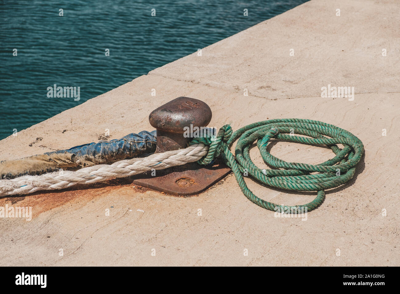 Seil von einem Schiff oder Boot festgebunden an einen Poller am Hafen closeup - Stockfoto