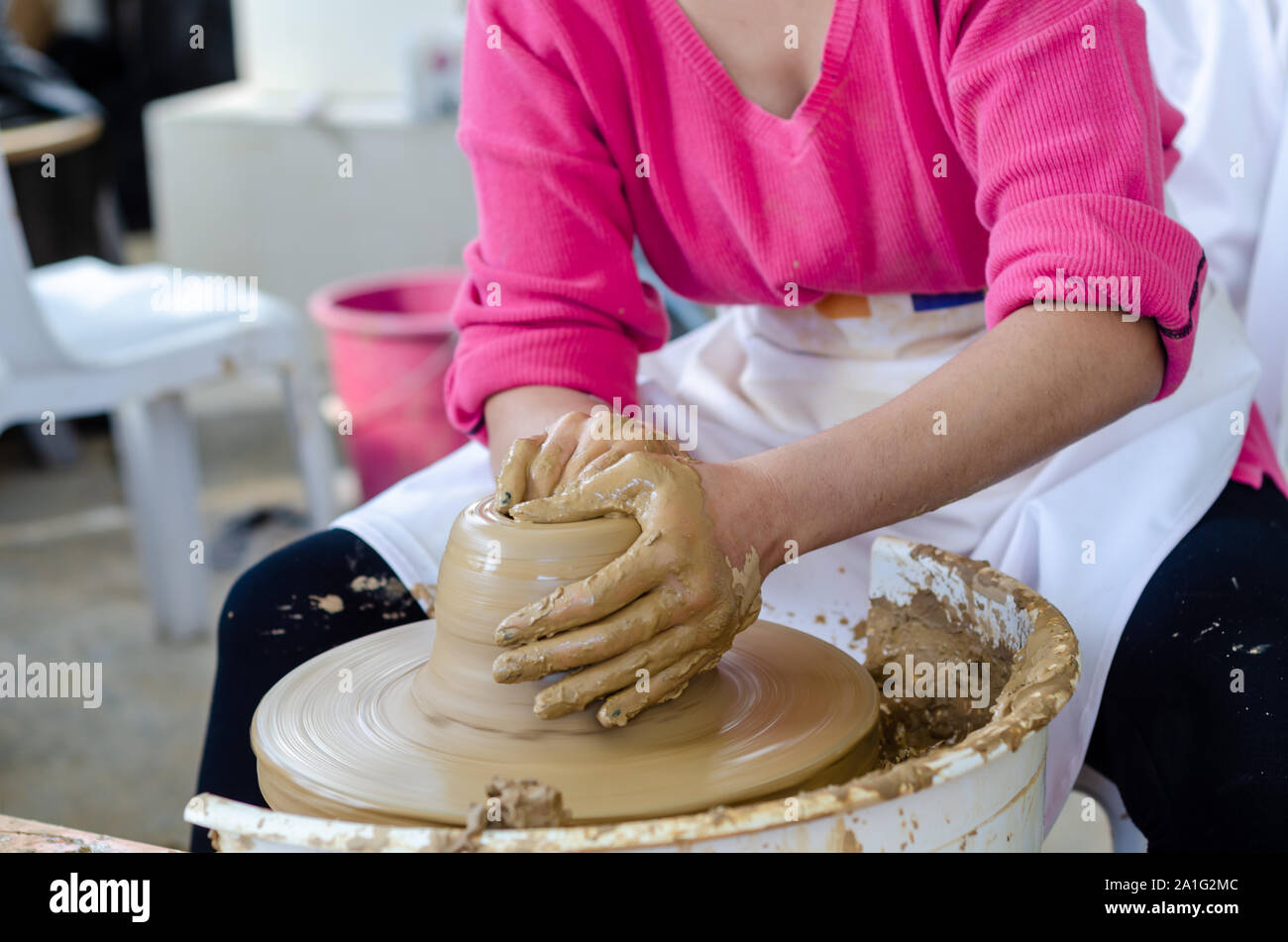 Keramische Arbeiten mit Lehm Töpferscheibe, aus der Nähe. Die Frau ist Töpfern im Studio. Stockfoto