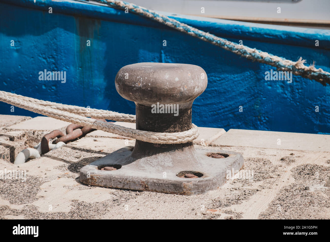 Seil von einem Schiff oder Boot festgebunden an einen Poller am Hafen closeup - Stockfoto