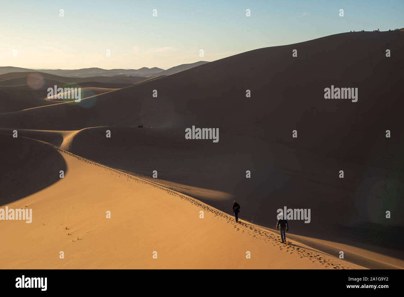 Menschen auf Sanddünen bei Sonnenuntergang in der Wüste von Marokko Stockfoto