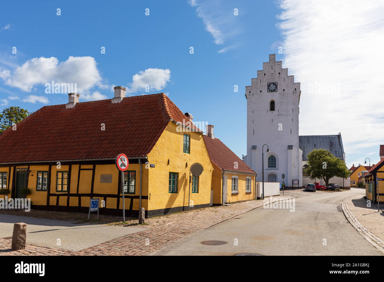 Bredebro Kirche und ein Gelbes Fachwerkhaus in Algade, Fjerritslev, Dänemark Stockfoto