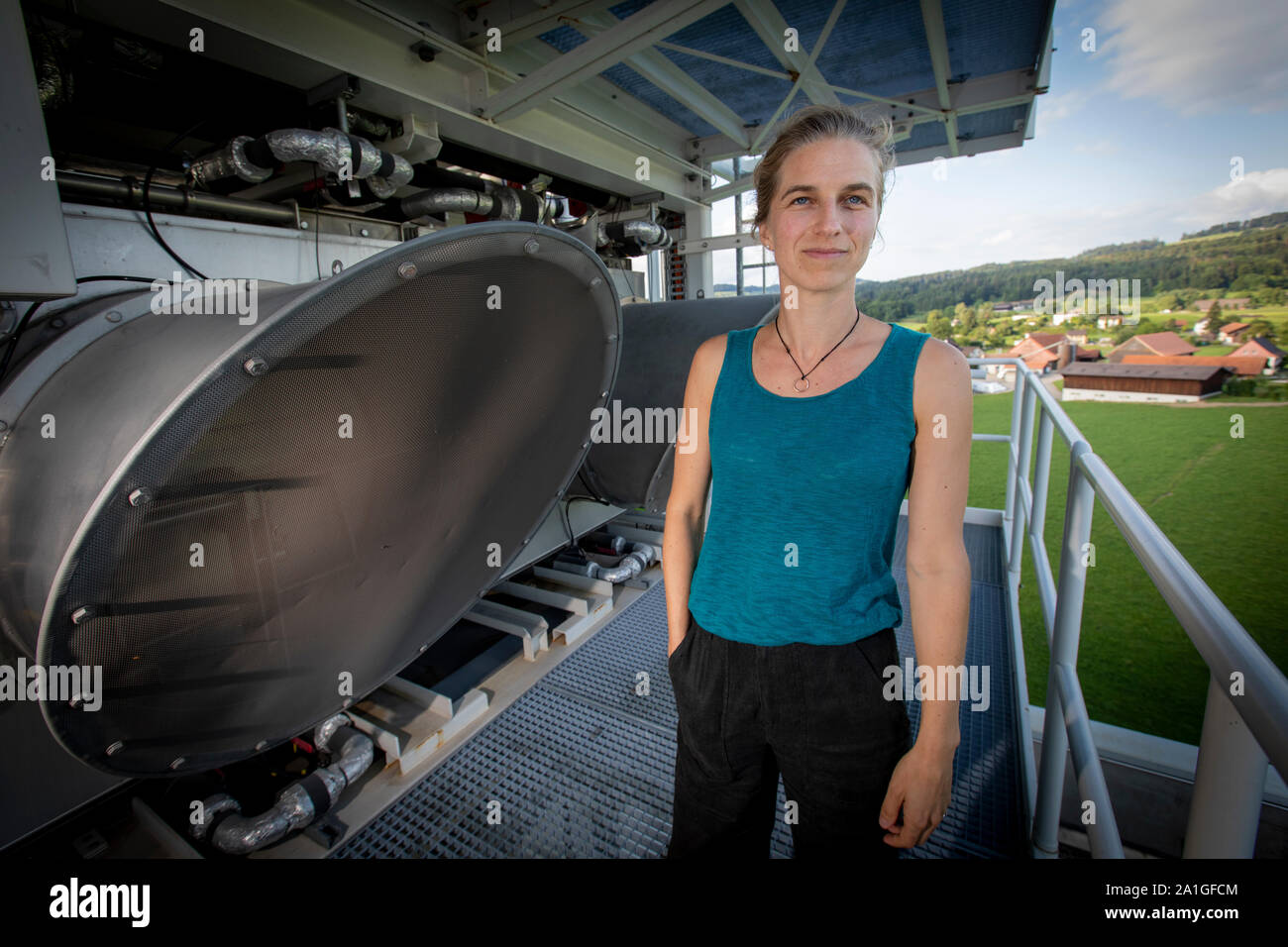 Louise Charles an Climeworks neben einem DAC 18. Die Schweizer Firma Climeworks laufen 30 DAC-Direct Air Capture-Ventilatoren auf dem Dach der Müll Verbrennungsanlage in Hinwil ausserhalb von Zürich. 2009 gegründet von Christoph Gebald und Jan Wurzbacher, hat das Unternehmen die modulare Carbon Capture Unit, von denen jeder in der Lage ist, saugen bis zu 135 Kilo CO2 aus der Luft täglich kommerzialisiert. Der Prozess wird Energie fordernd, und die Einheiten in Hilwil erhalten Sie die Leistung von der Verbrennungsanlage. Wiederum wird das CO2 in die benachbarten Gewächshäuser gepumpt, die Produktion von Tomaten und Gurken an accellerate. Stockfoto