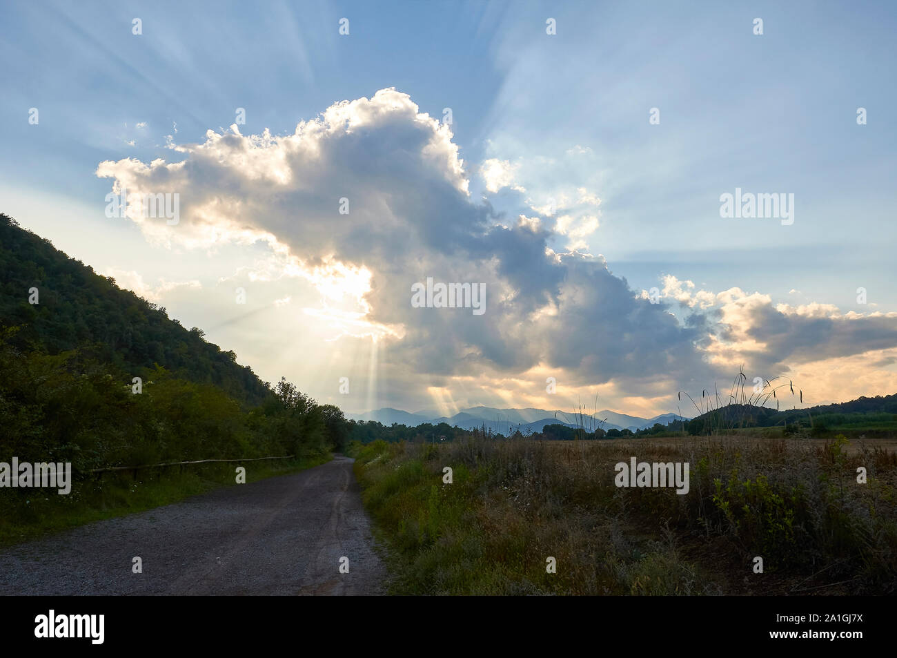 Sonnenuntergang mit Wolken und Sonnenstrahlen in Fußweg rund um El Croscat Vulkan in Garrotxa vulkanischen Zone Naturpark (Santa Pau, La Garrocha, Girona, Spanien) Stockfoto