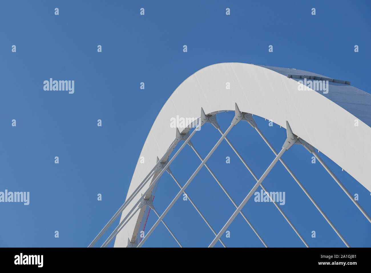 Nahaufnahme der weißen Bogen Stahlträger starre Struktur und Tragseile durchgeführt Dach der Arena Dome gegen den tiefblauen Himmel. Stockfoto