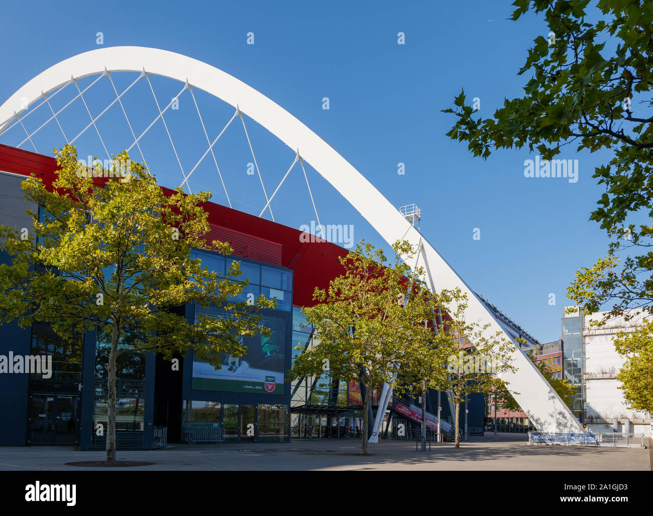 Lanxess Arena, Indoor multifunktionale Arena, mit Glasfassade und roten Aluminiumplattierung, und lange Zeitspanne Dach von weißen Stahl arch Strahl unterstützt. Stockfoto
