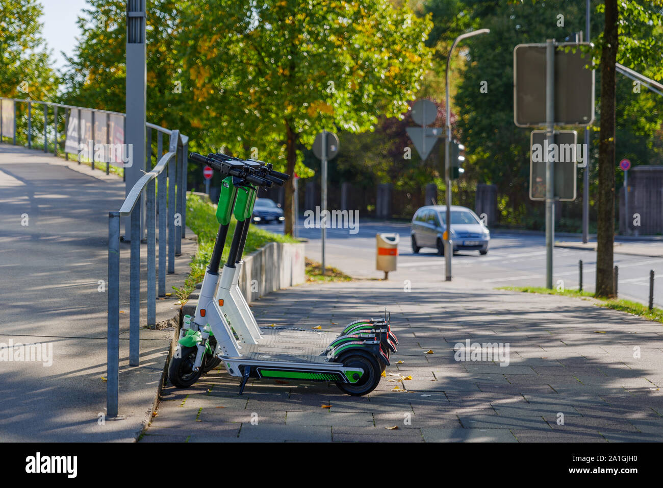 Gruppe von E-Scooter von Start-up-Unternehmen mit der Idee der Umweltfreundliche Mobilität für urbanen Lebensstil und durch die gemeinsame Nutzung von Elektroroller, Park auf schattigen Bürgersteig Stockfoto
