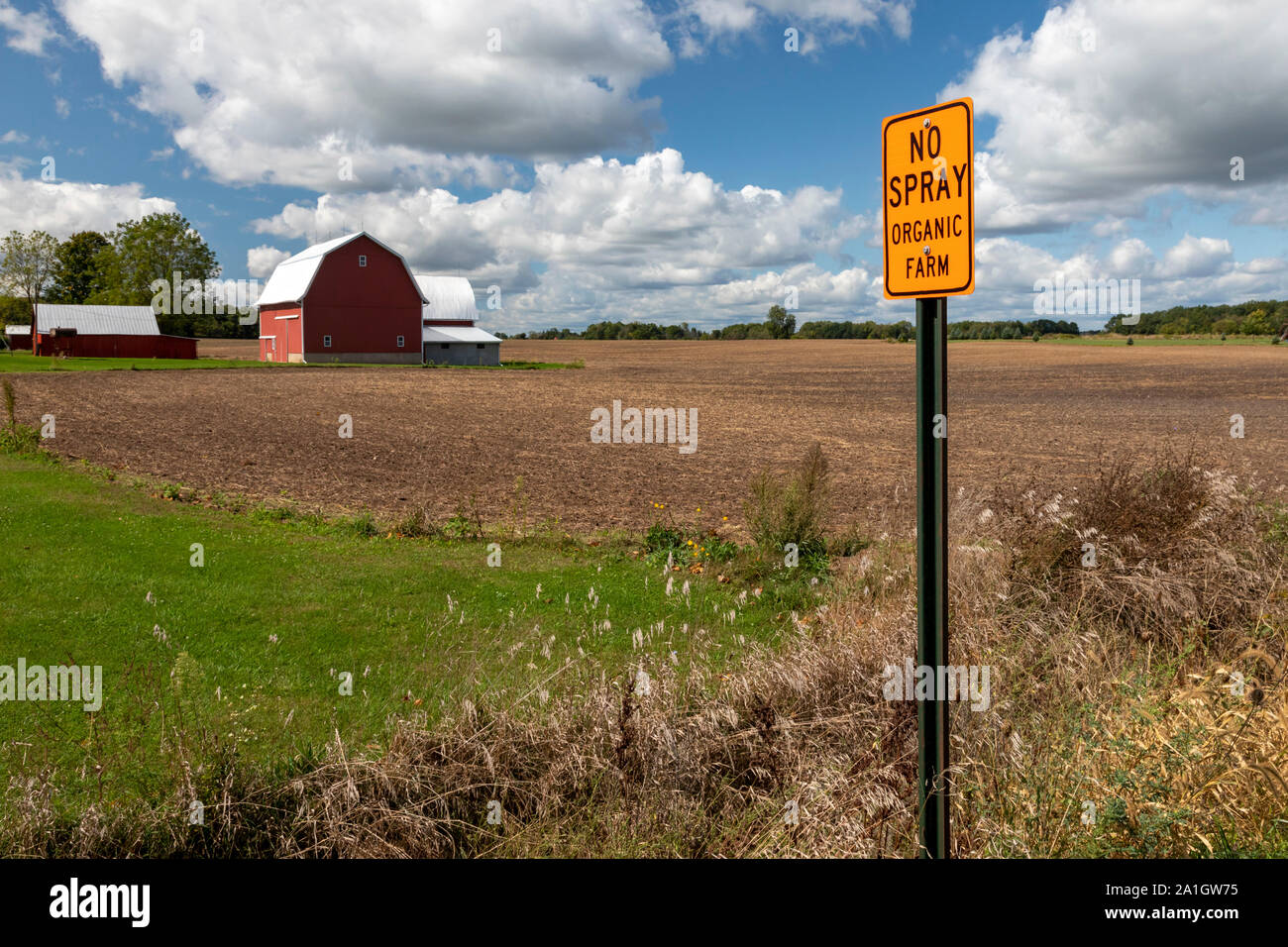 Westfalen, Michigan - ein Schild warnt vor sprühen Chemikalien in der Nähe von einem Bio-Bauernhof. Herbizide sind häufig entlang der ländlichen Straßen gesprüht Unkräuter. Stockfoto
