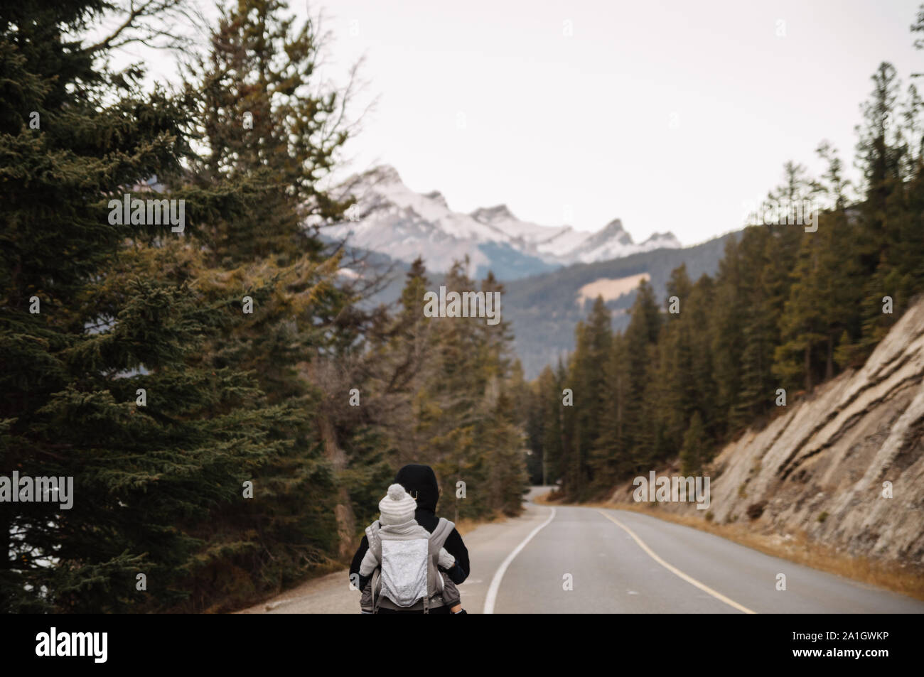 Frau mit Baby entlang eine Landstraße in den Bergen Stockfoto