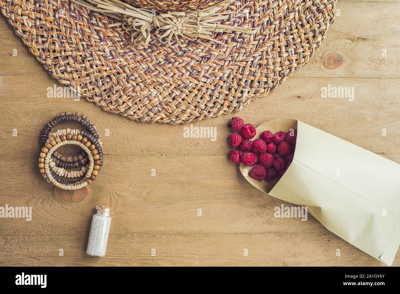 Sommer Urlaub, Ferien, Entspannung Konzept. Himbeeren, Strohhut, Handy, Smartphone, Kopfhörer, Sonnenbrillen von oben, Ansicht von oben, flach Stockfoto