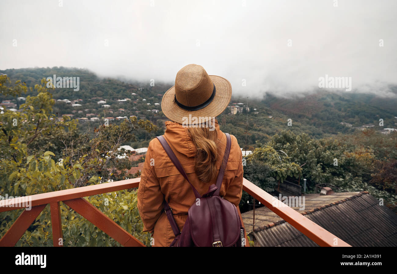 Touristische Frau in hat ist auf nebeligen Hügeln in Signagi, Georgien Stockfoto