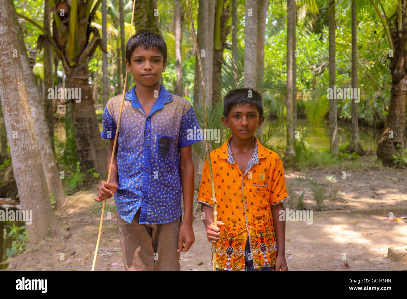 Asiatische oder Bangladeshi Dorf Kinder sind zusammen mit Ihren Angeln Stick Stockfoto