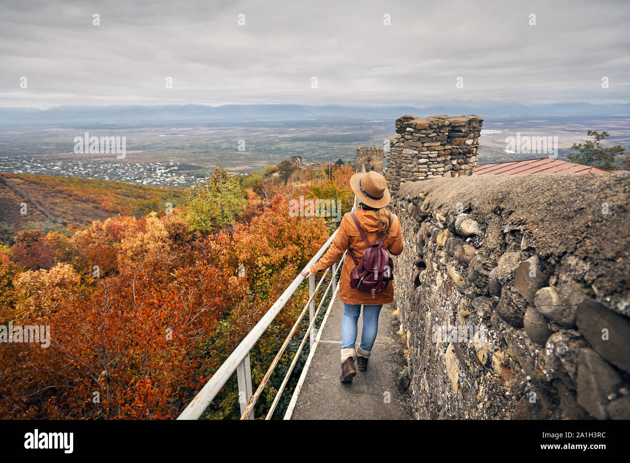 Touristische Frau gehen mit Stadtmauer aus Stein in Signagi, Georgien Stockfoto