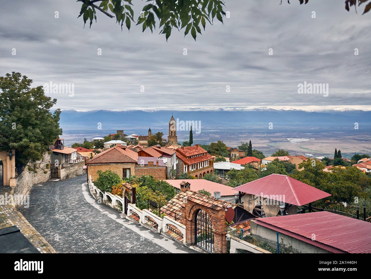 Kirche und Häuser an der Straße von signagi Stadt mit alasani Tal und die Berge im Hintergrund in Georgien Stockfoto