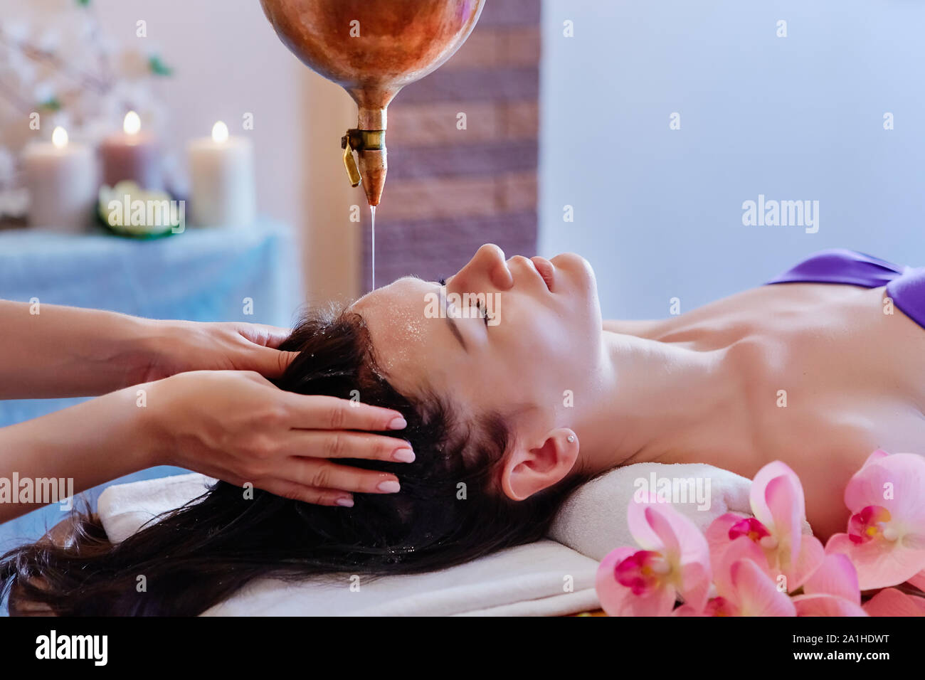 Junge Frau in Gießen öl Massage Spa Behandlung. Shirodhara gießen Öl auf den Kopf. Behandlung von Kopf Stockfoto