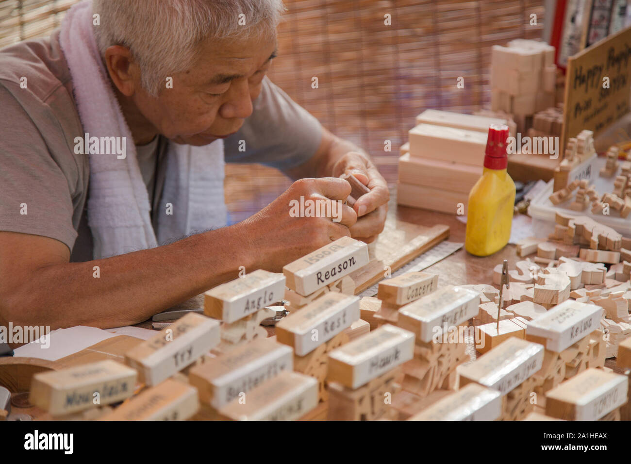 Senso-ji Tempel, Tokio, Japan. Die älteren Künstler schafft Japanische Zeichen form Holz vollständig von Hand zum Verkauf mit zweisprachigen Präsentation. Stockfoto