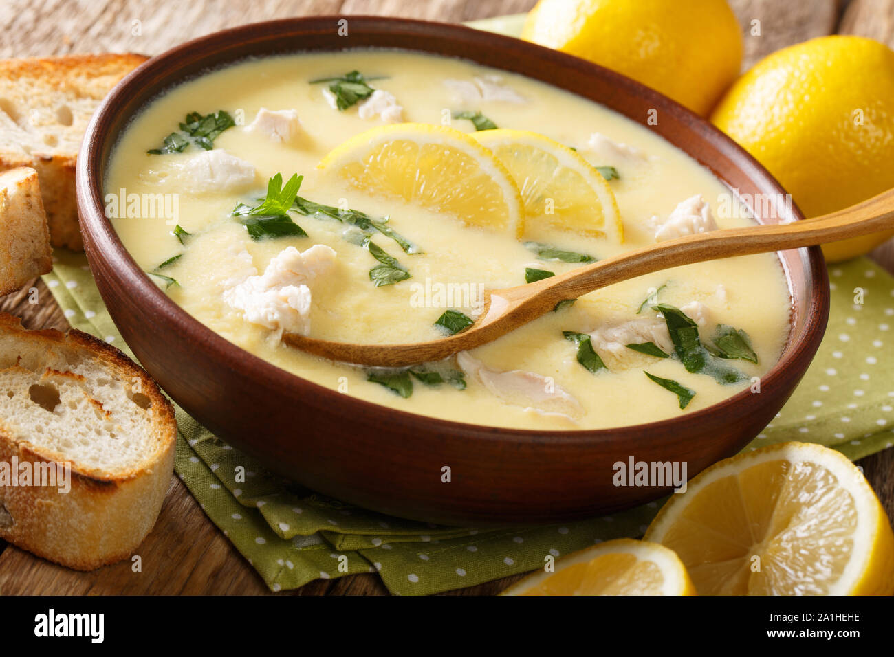 Frische griechische Zitronen Suppe mit Hähnchen und orzo Einfügen close-up in einer Schüssel auf dem Tisch. Horizontale Stockfoto
