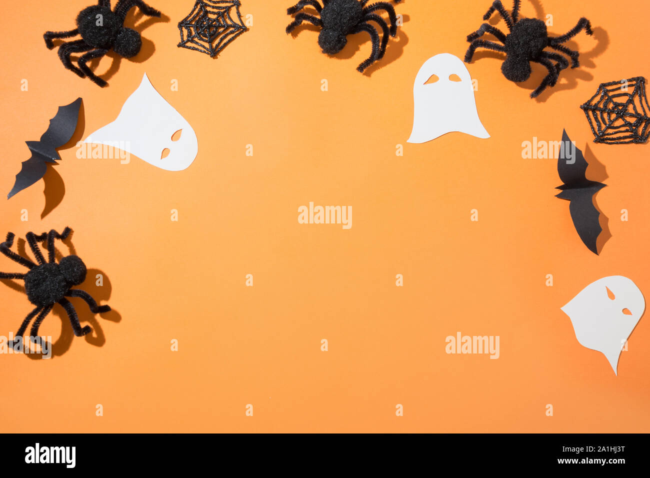 Halloween Grenze von Spinnen, Geist und Fledermaus auf orangefarbenen Papier. Flach, Ansicht von oben. Kreative Halloween Tag Zusammensetzung. Platz für Text. Stockfoto