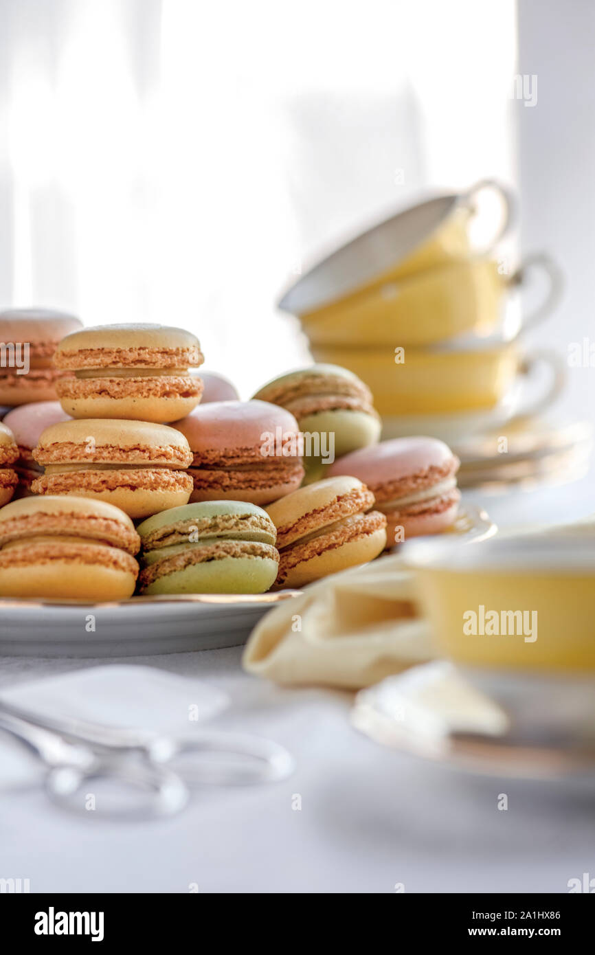 Selektiver Fokus einer Platte voller Macarons in der Nähe der hübschen gelben Tassen im Hintergrund Bilder mit Kopieren und Platz für Text-overlay Stockfoto