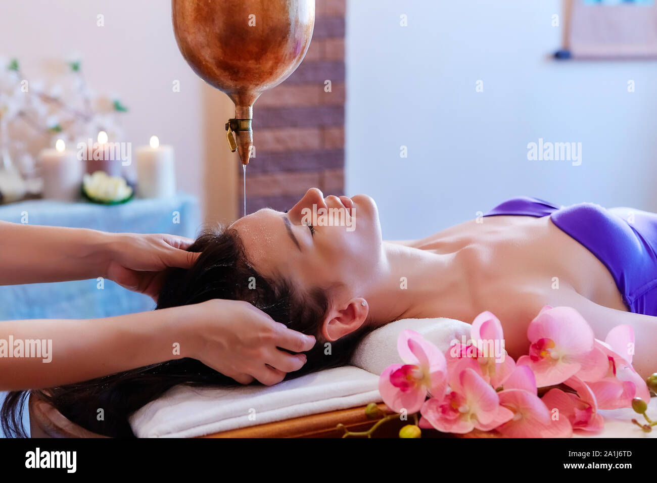 Junge Frau in Gießen öl Massage Spa Behandlung. Shirodhara gießen Öl auf den Kopf. Behandlung von Kopf Stockfoto