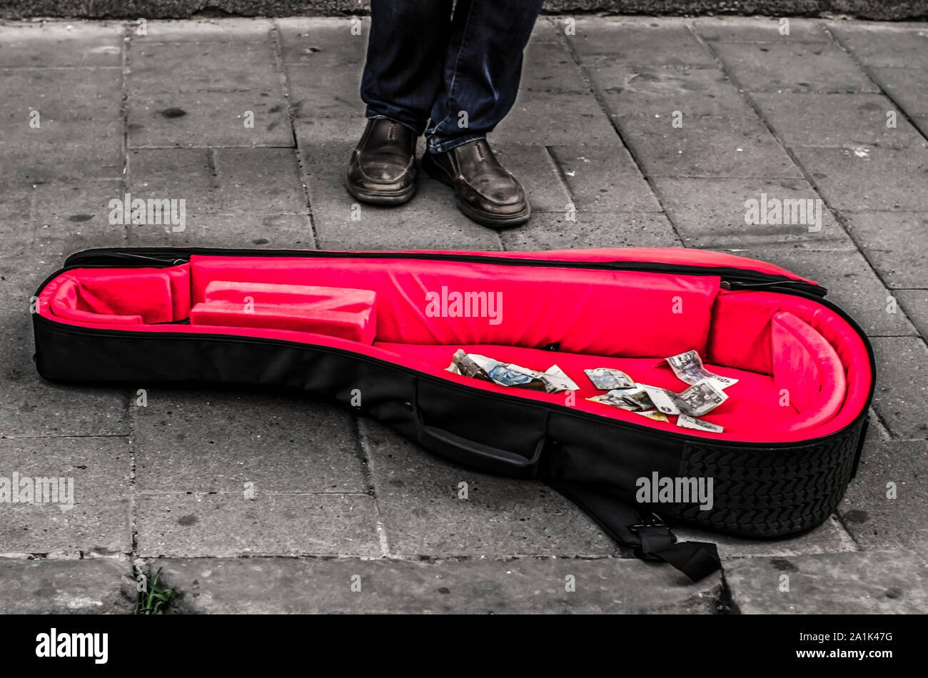 Cello Case mit rotem Samt mit Geld. Foto - Straßenmusiker. Schwarz-weiß Foto. Stockfoto