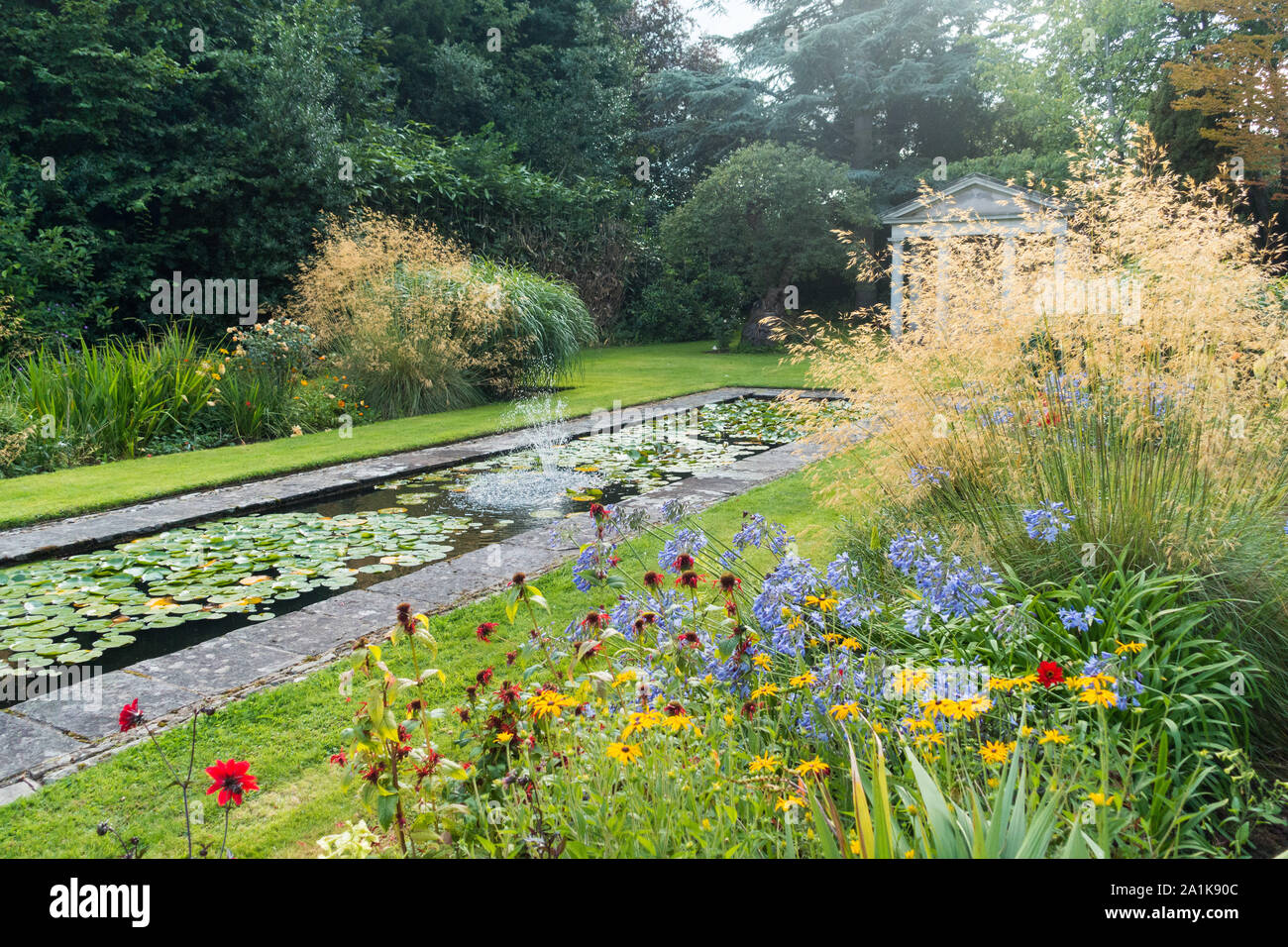 Die wunderbare Wirkung von Gräsern in einem Garten mit Teich Stockfoto