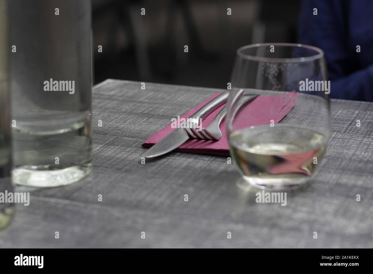 Die Abbildung zeigt ein Cafe oder Restaurant Tabelle einschliesslich Besteck, Serviette und einem Glas Wasser und einer Flasche Wasser Stockfoto