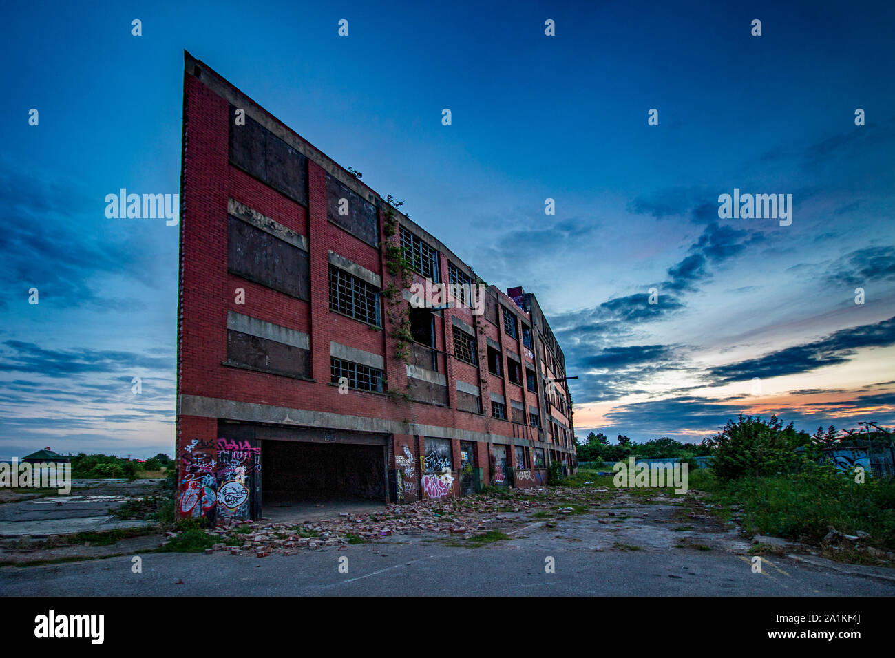 Verfallenes Gebäude mit kaputten Fenstern und Verschmutzungen unter ein Abendhimmel Stockfoto