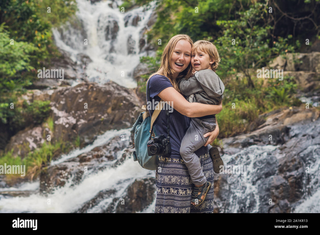 Mutter und Sohn im Hintergrund des wunderschönen, kaskadierenden Datanla-Wasserfalls in der Bergstadt Dalat, Vietnam Stockfoto