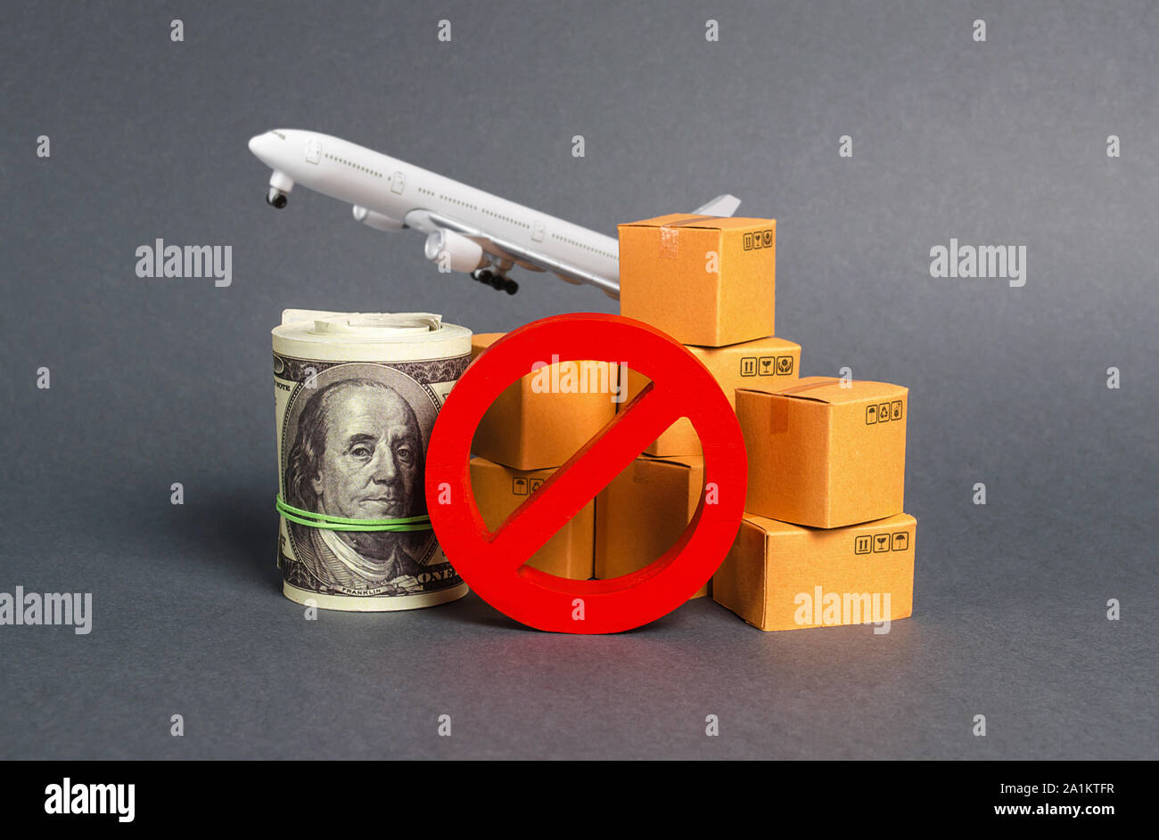 Das Verbotsschild keine Blöcke, Bündel von Dollar Geld und Boxen mit einem Flugzeug. Embargo, Handelskriege. Beschränkung bei der Einfuhr waren, proprietäre Stockfoto