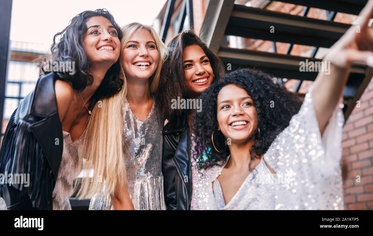 Vier Frauen auf der Straße an einem Punkt und lächelnd Stockfoto