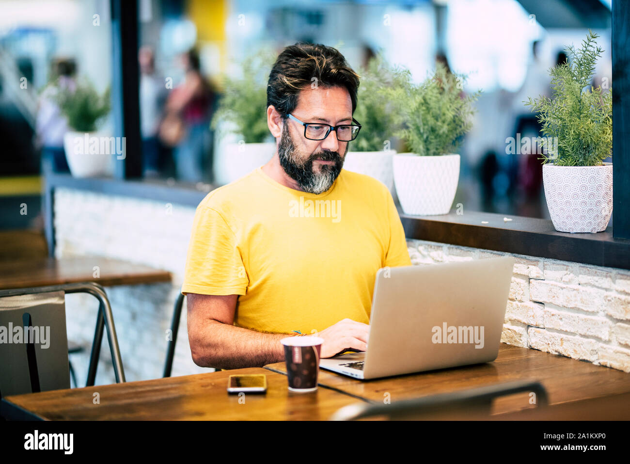 Hipster Mann am Laptop in der Coffee Bar mit Internet Wifi Anschluss  kostenlos - alernative Workstation für digitale Traveler die Bärtigen  Stockfotografie - Alamy