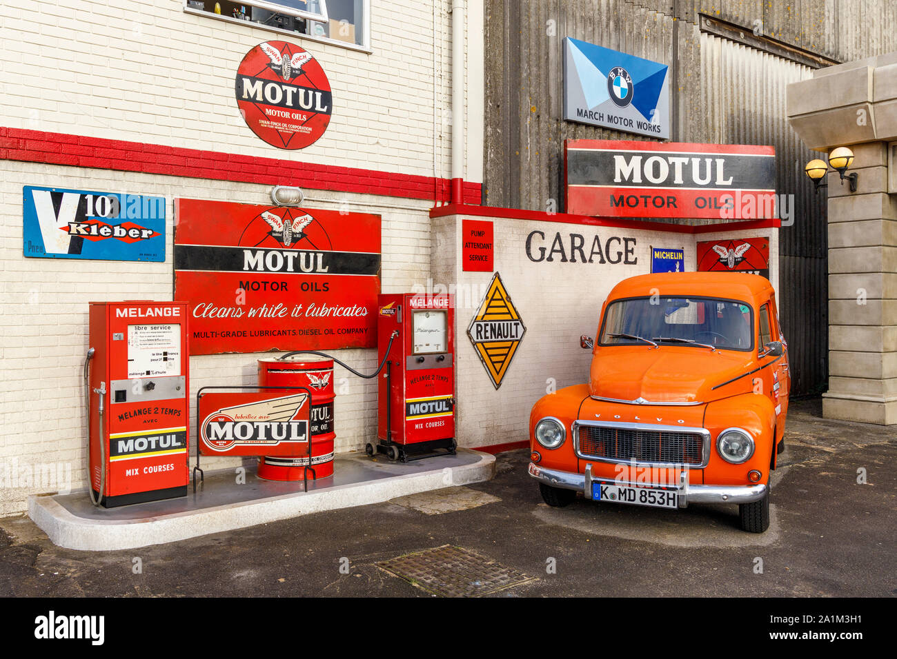 Simulierte Motul Garage mit einem orangen Volvo Amazon auf dem Vorplatz. An der 2019 Goodwood Revival, Sussex, UK angezeigt. Stockfoto
