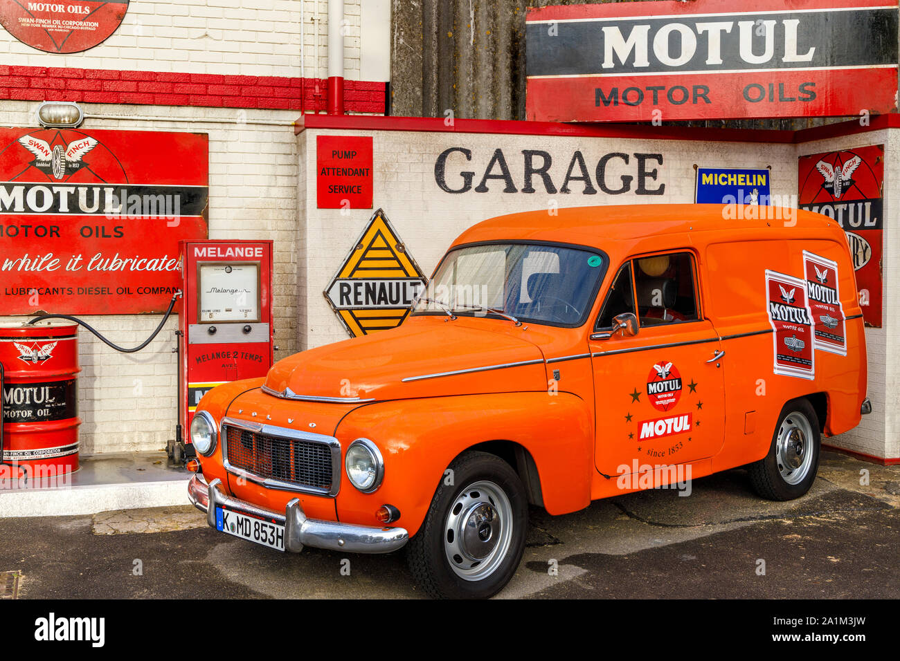 Simulierte Motul Garage mit einem orangen Volvo Amazon auf dem Vorplatz. An der 2019 Goodwood Revival, Sussex, UK angezeigt. Stockfoto