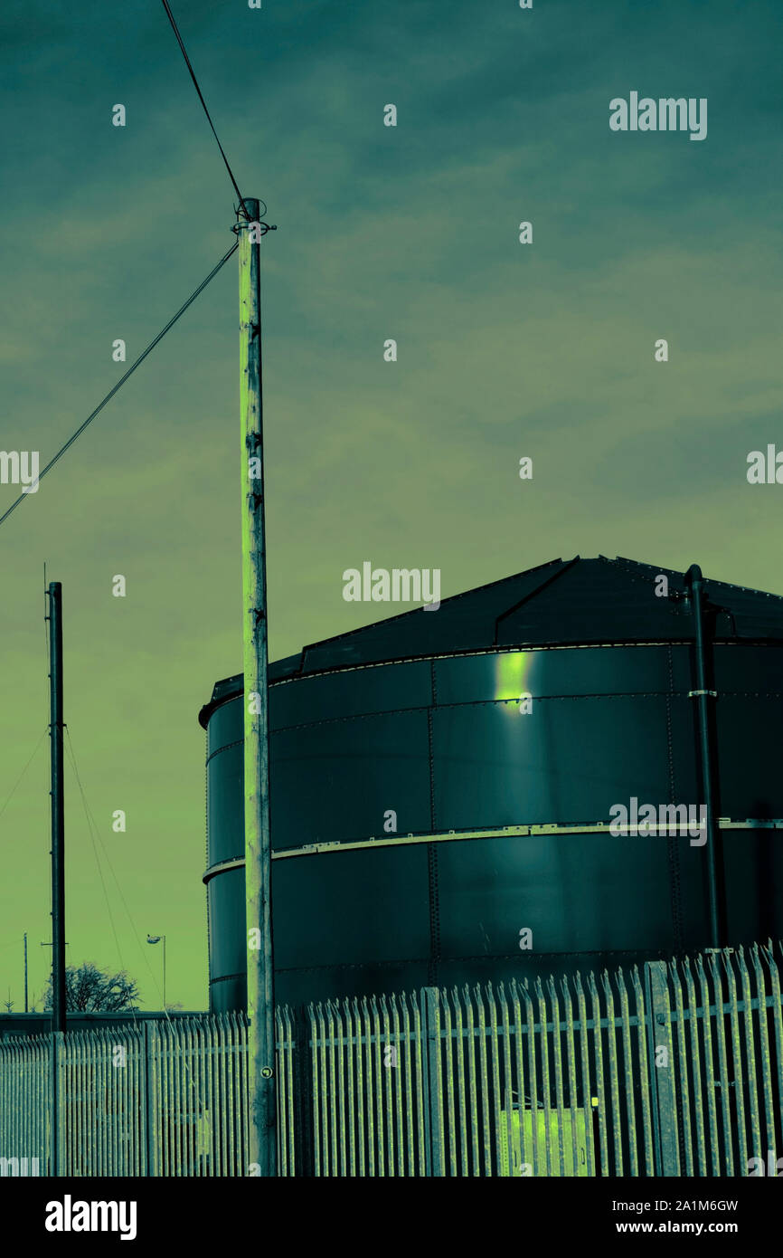 Städtische Szene der industriellen Tank und Telefonmast gegen den Himmel. Retro Ton Wirkung. Stockfoto