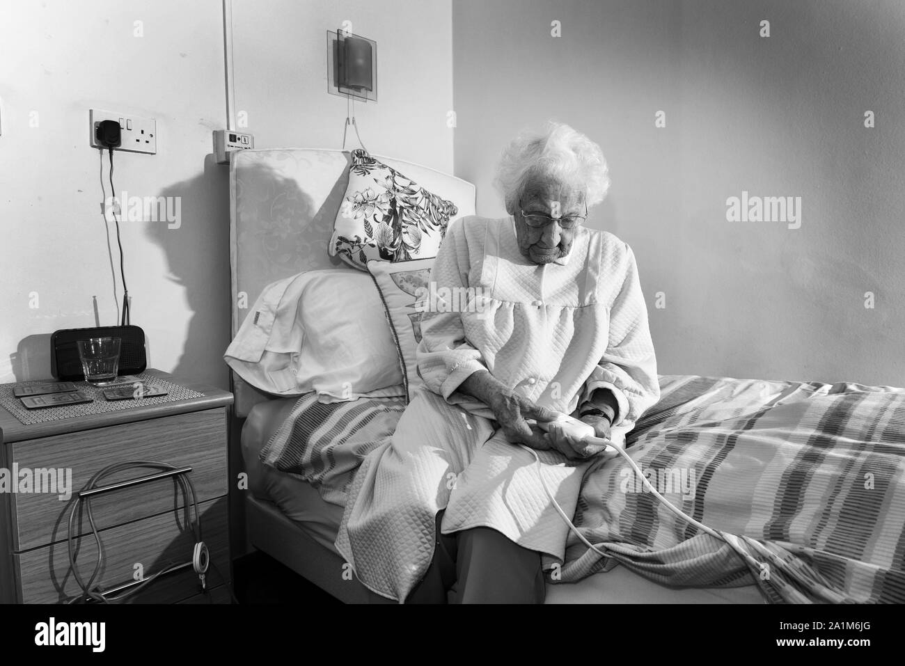 Ältere Dame zu Bett gehen mit einer Heizdecke Großbritannien Großbritannien Stockfoto
