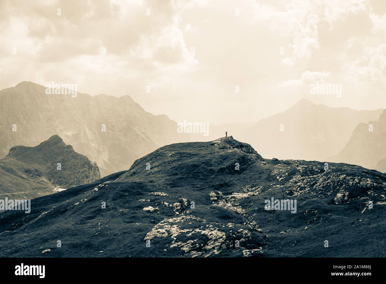Frau alleine auf dem Gipfel zwischen riesigen Bergketten in der wunderschönen Natur. Sommer Tag Panorama. Julische Alpen, Nationalpark Triglav, Slowenien. Stockfoto