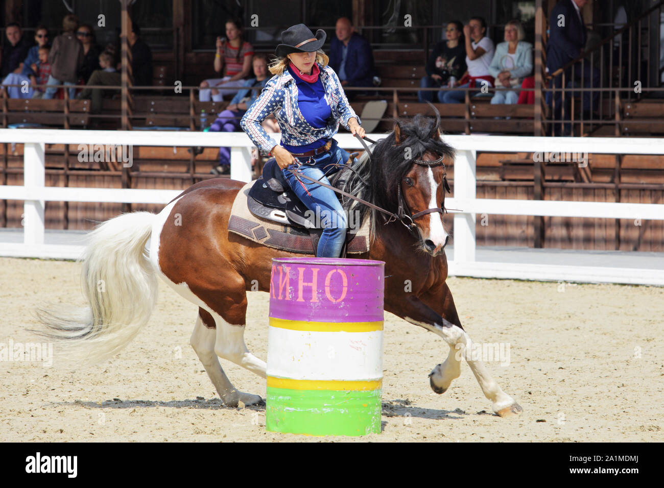 Weibliche Cowgirl und Cowboy in Barrel Racing Event mit Pferd Stockfoto