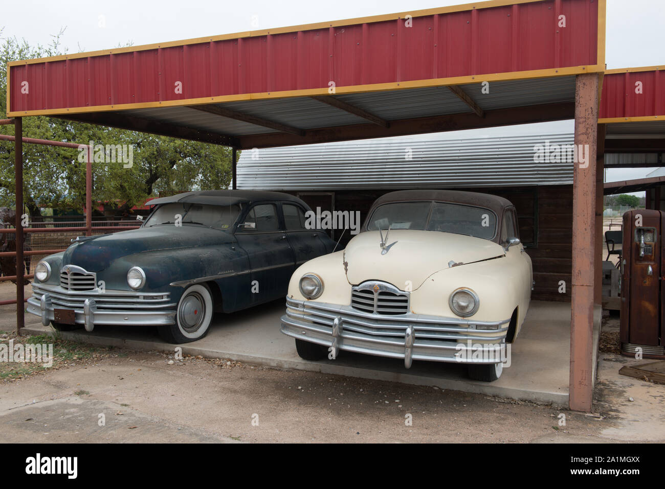Alte Autos unter einer Markise an einem neu erstellt, Shell Tankstelle an der Töpferei Ranch Töpferei in Marble Falls, Texas Stockfoto