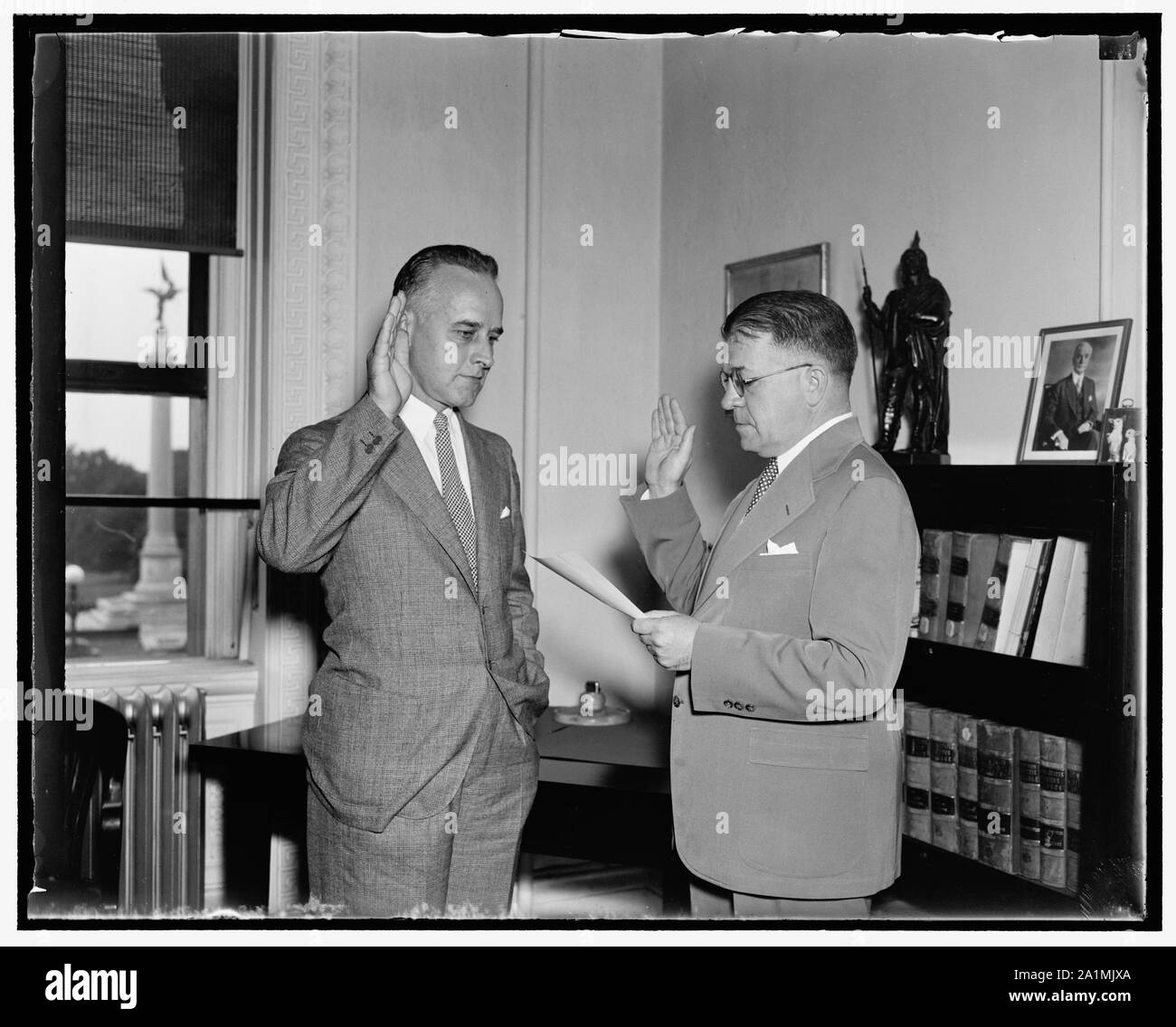 Alte schwört in der Neuen. Washington, D.C., Aug. 9. C.E. Maceachran, (rechts) in den Ruhestand Prokurist der Staatlichen Abteilung, Verwaltung der Amtseid auf seinen Nachfolger, Edward Yardley. Yardley war früher ein Rechtsanwalt der amerikanischen Agentur der allgemeinen Forderungen der Kommission. Der Posten des Prokuristen der Abteilung Staat trägt auch der Titel der Administrative Assistant, 9/9/37 Stockfoto