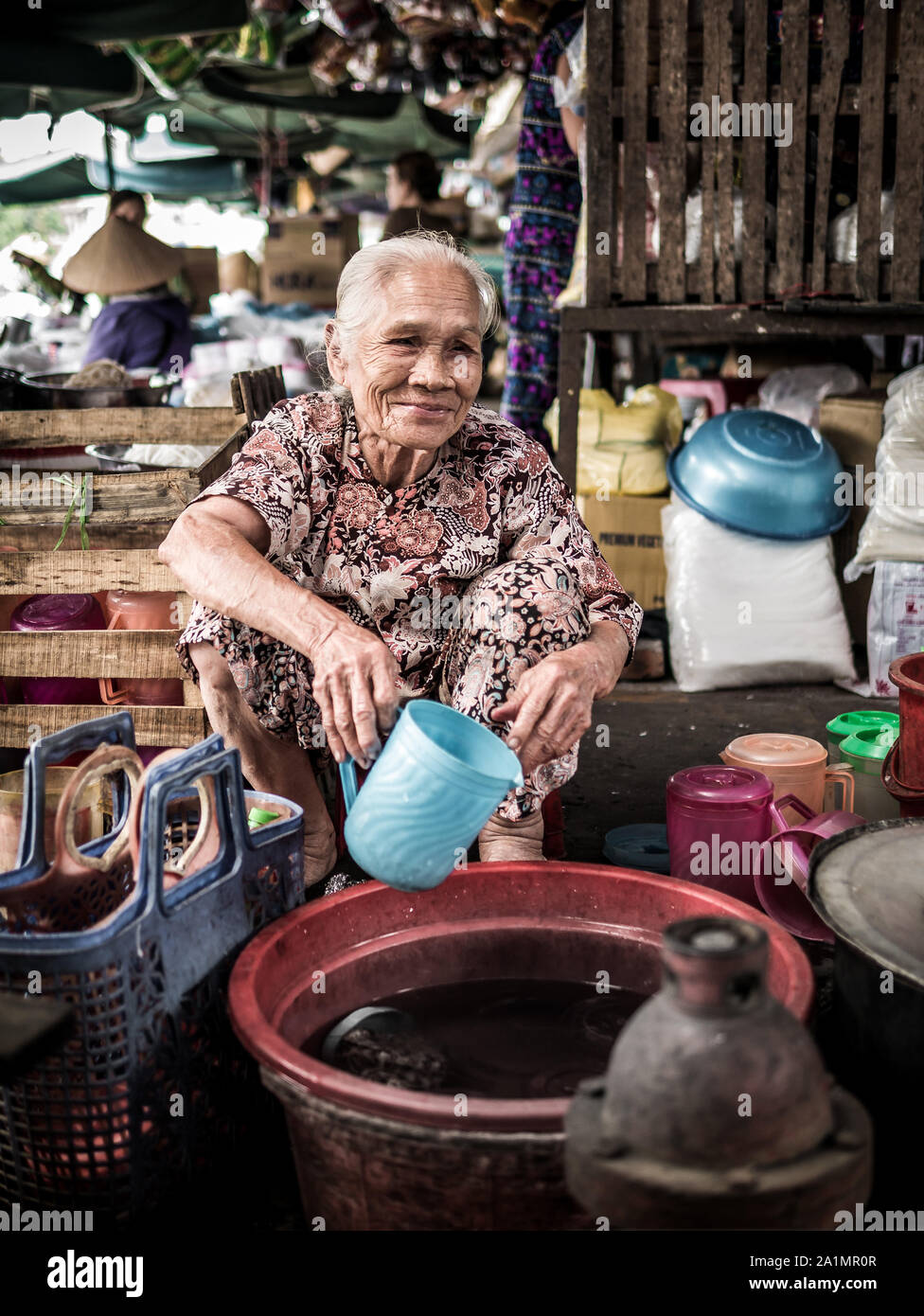 Vietnamesische ältere Dame mit Plastik kanne Street Market in Hue, Vietnam Stockfoto