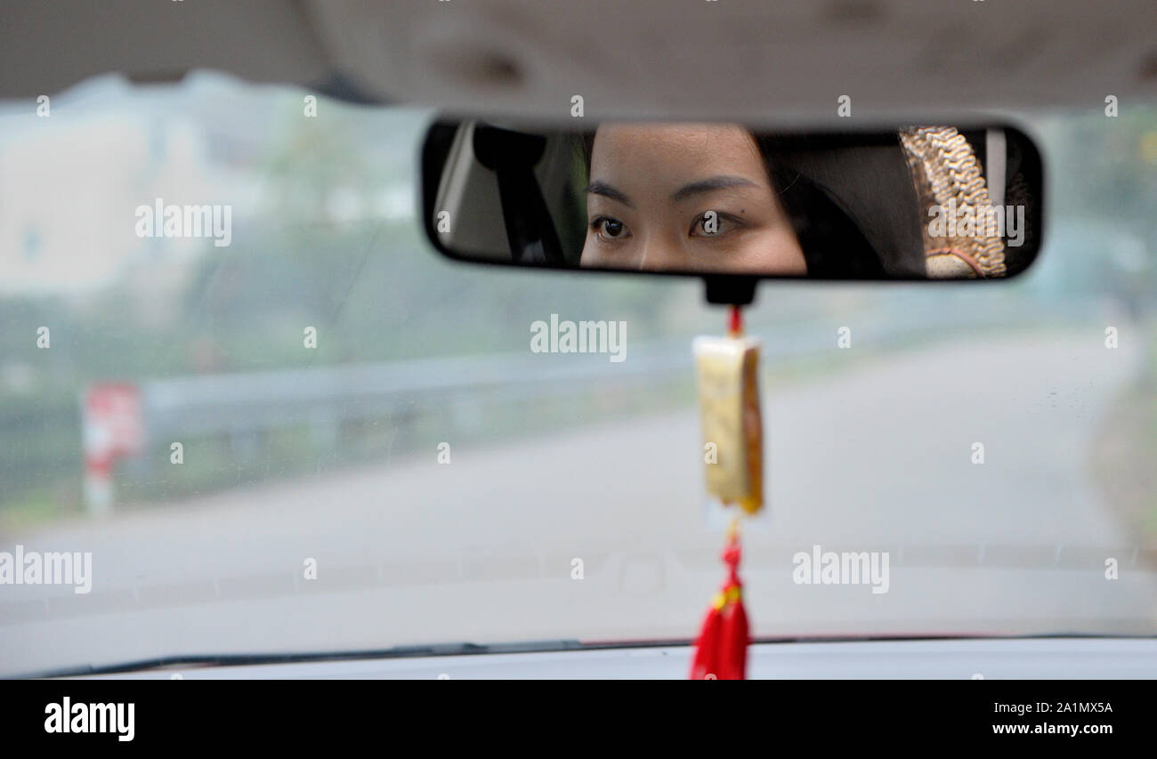 Die schöne Augen eines weiblichen chinesischen Autofahrer in der Zurück-Spiegel (China). Stockfoto