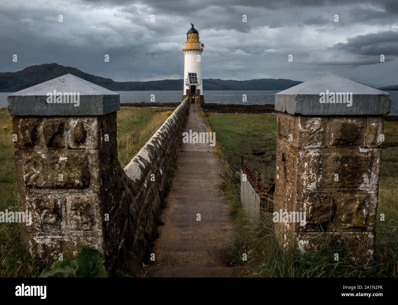 Tobermory Leuchtturm, auf der Insel Mull, mit Steinmauern und Weg zum Leuchtturm im Hintergrund. Führende Linien. Fluchtpunkt. Argyll Stockfoto