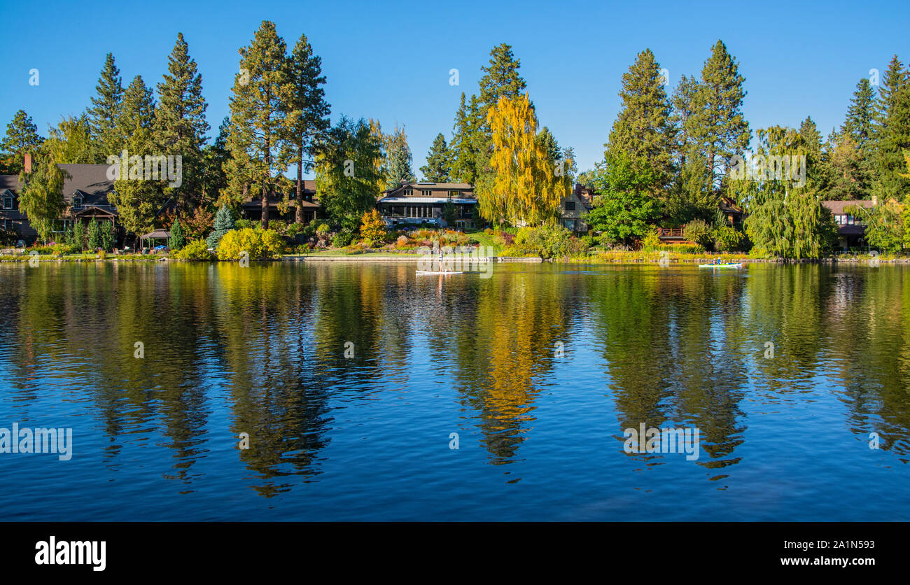 Oregon, Bend, Downtown, Spiegel Teich, Frau und Hund auf Stand up Paddle Board Stockfoto